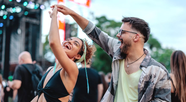 Tanzendes Paar auf einem Festival mit fröhlichen Gesichtern und festlicher Atmosphäre.
