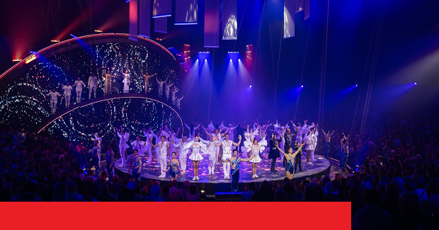 Bühne mit talentierten Künstlern in funkelnden Kostümen bei einer spektakulären Show vor begeistertem Publikum.
